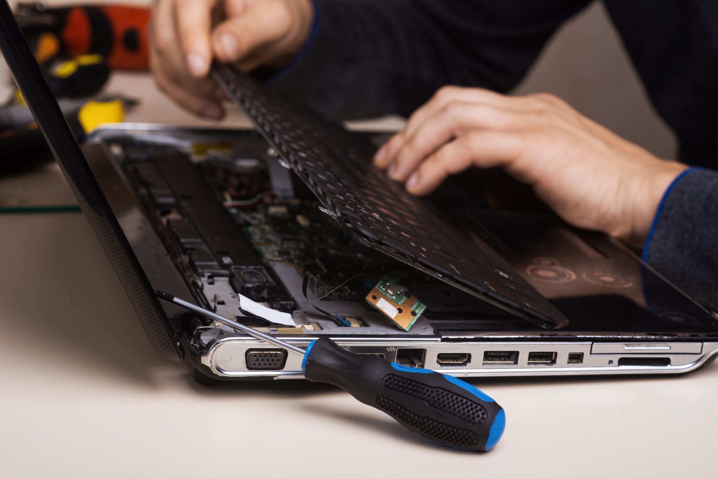 Wizard repairs laptop with tools and hands